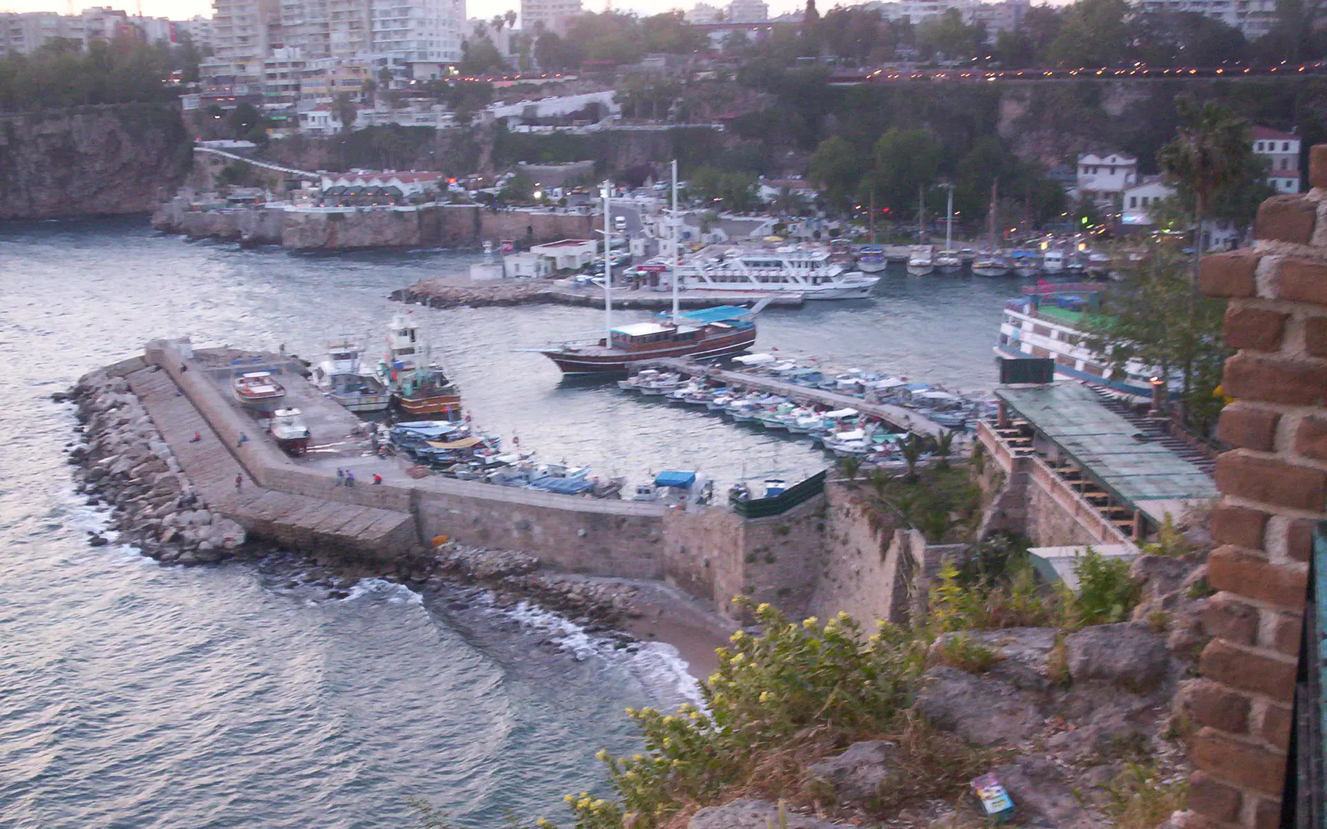 The old harbour at Antalya seen from the city walls, boats moored below.