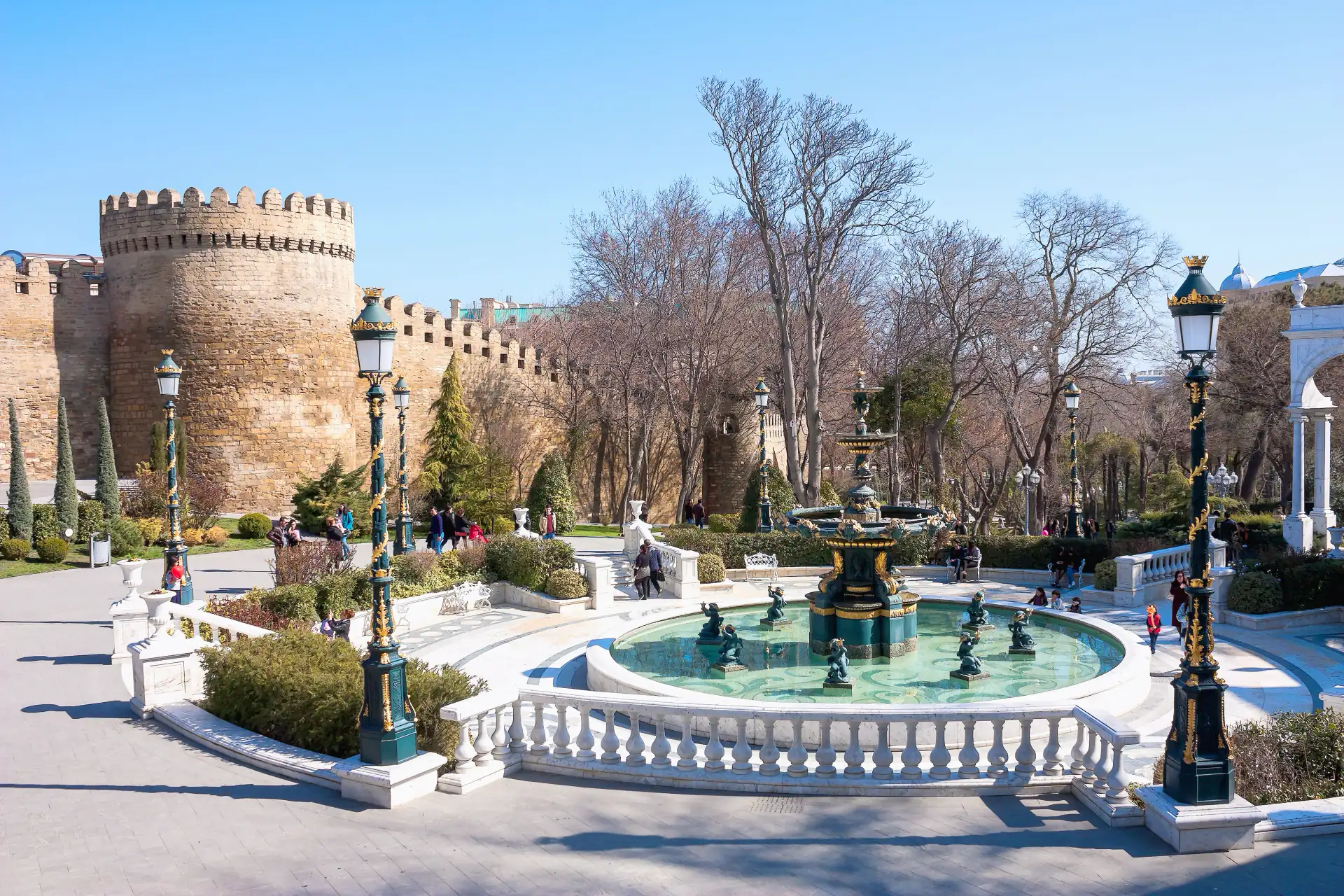 The walls and towers of Baku’s old city above a fountain square.