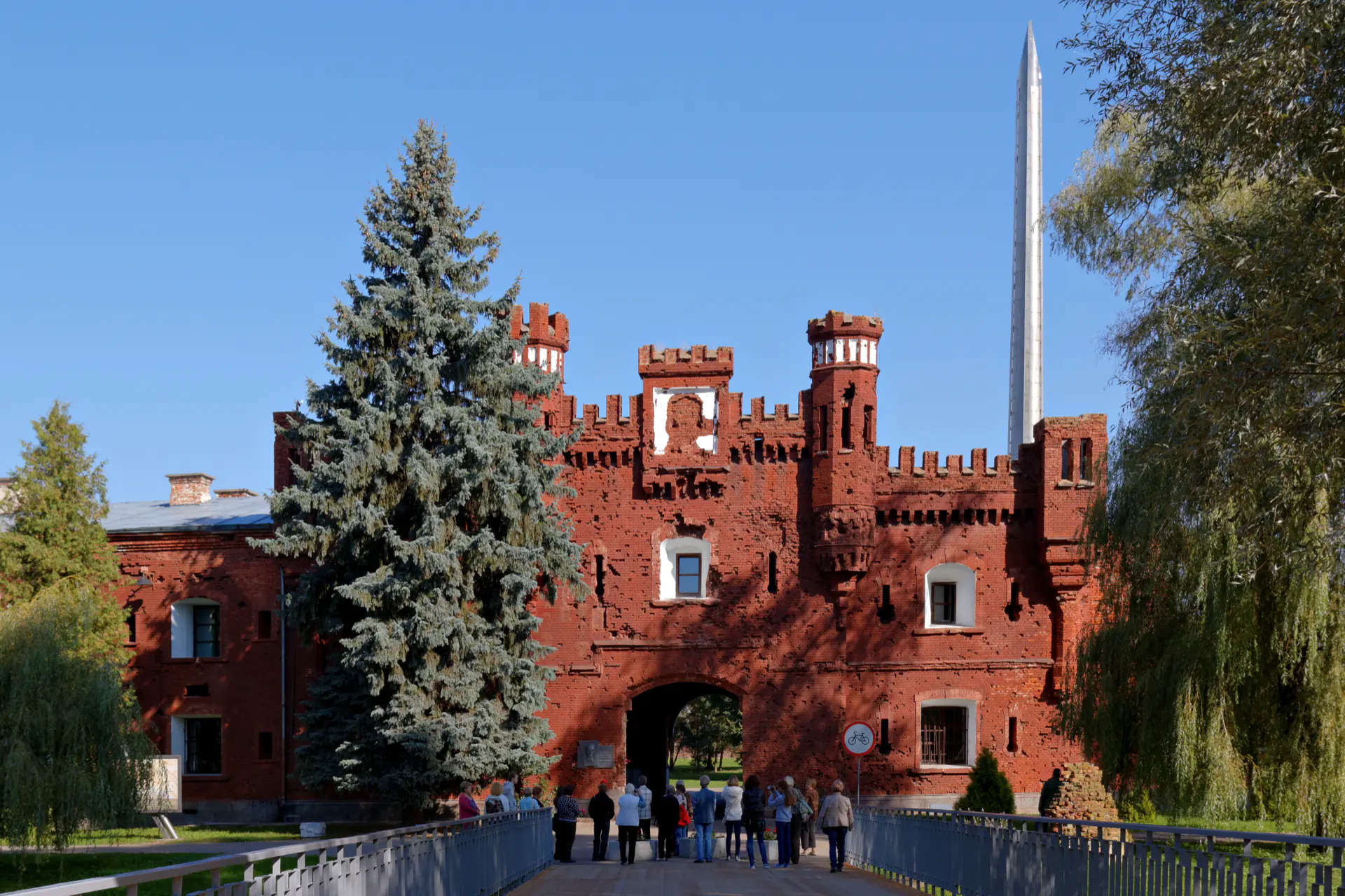 A red-brick gate of the Brest Fortress complex, seen from the approach road.