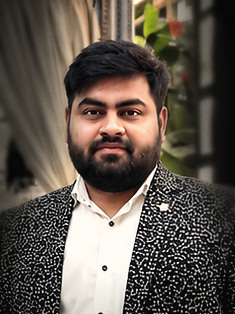 Dr Arvind Pratap, bearded, in a patterned jacket over an open white shirt, looking at the camera.