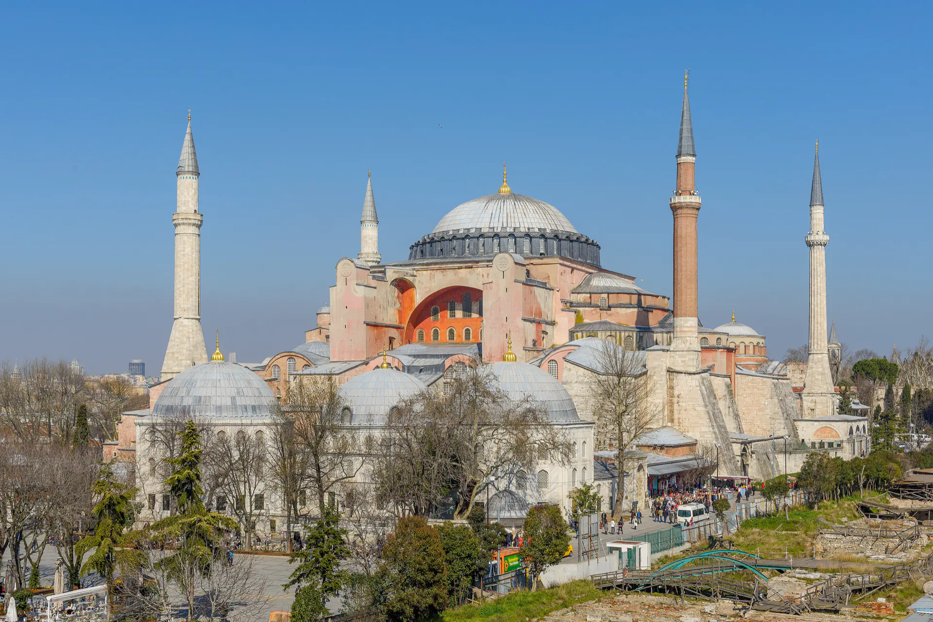 Hagia Sophia from the square, its dome and four minarets above the plane trees.