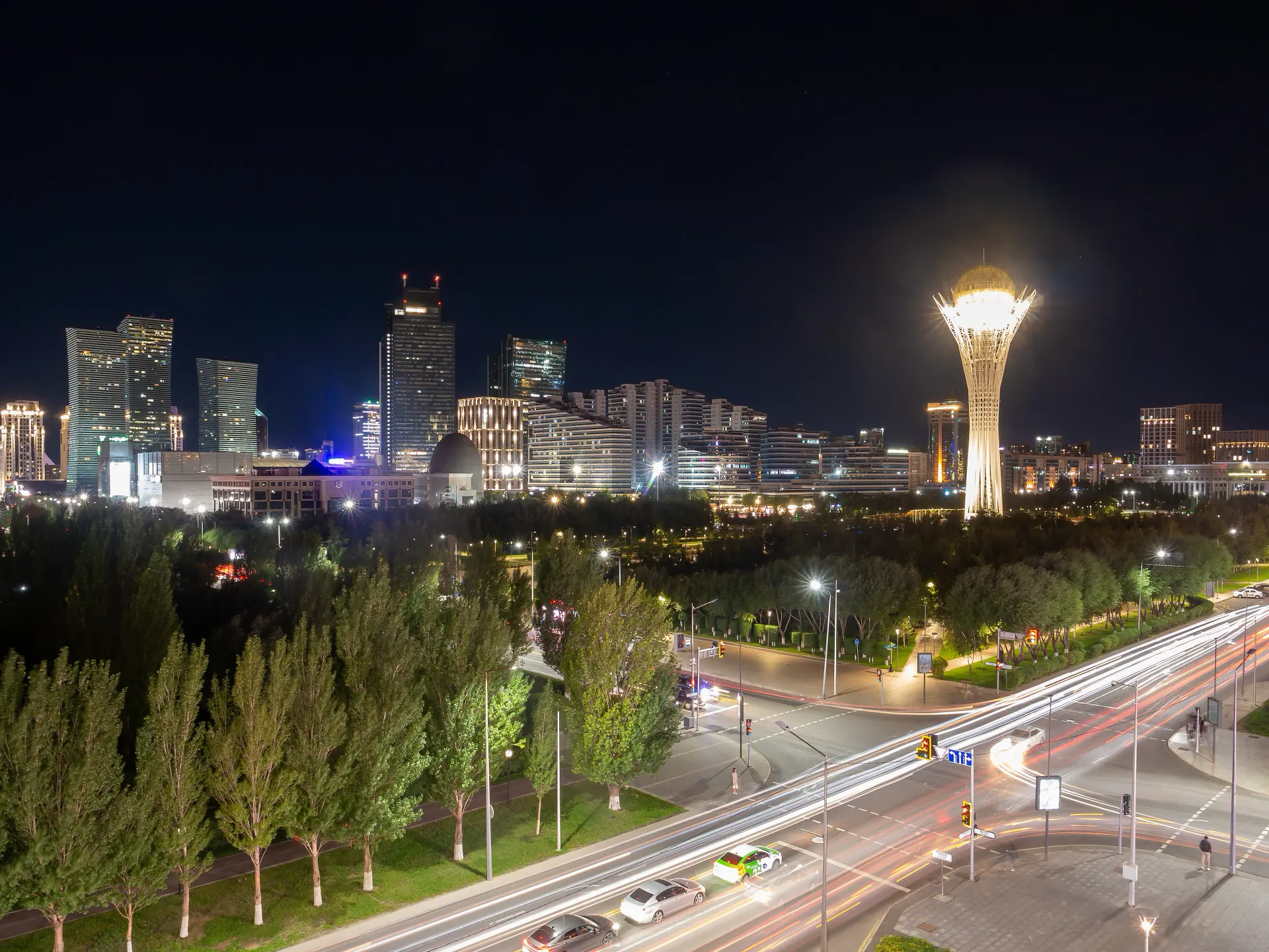 The planned Esil district of Astana lit at night, towers along the central axis.
