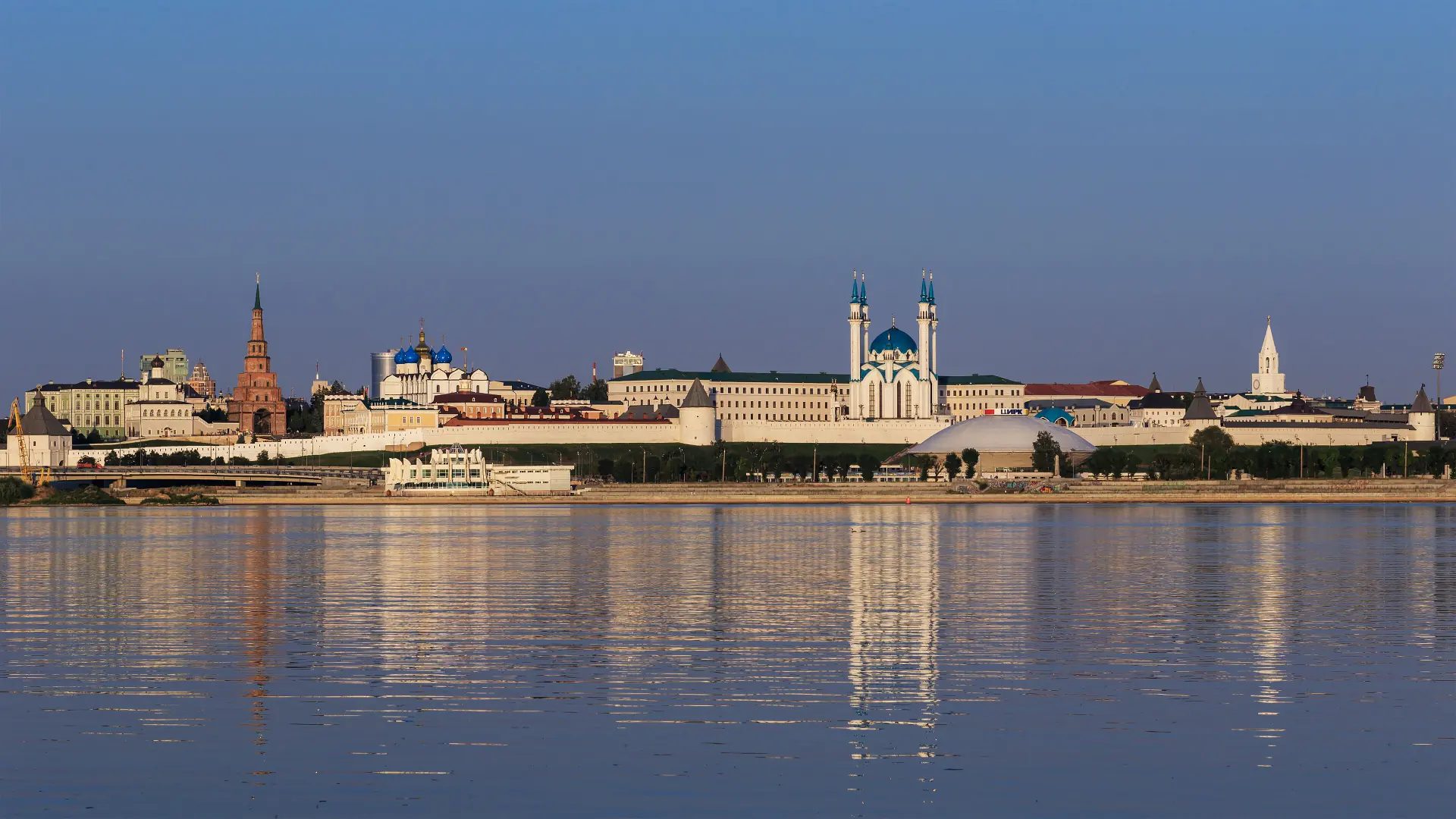 The white walls of the Kazan Kremlin with the blue minarets of the Qolşärif mosque behind.
