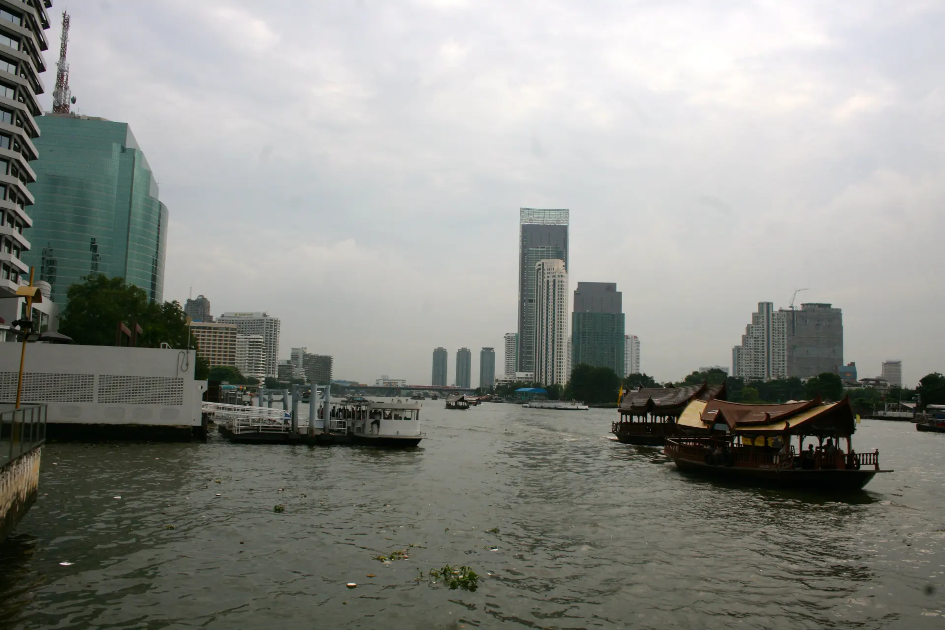 A rice barge on the Chao Phraya with the Bangkok skyline behind it.