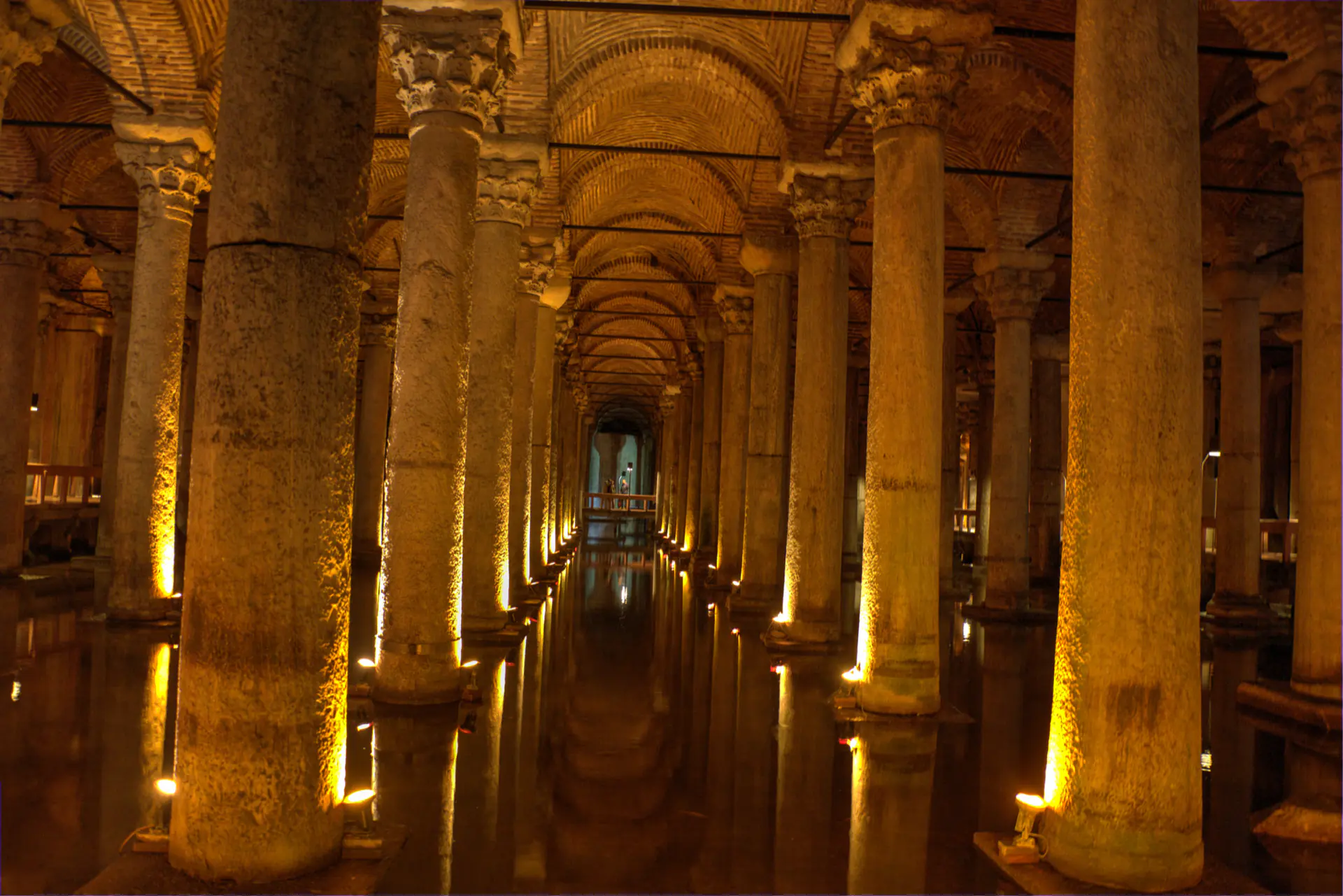 The lit colonnade of the Basilica Cistern receding into the dark.