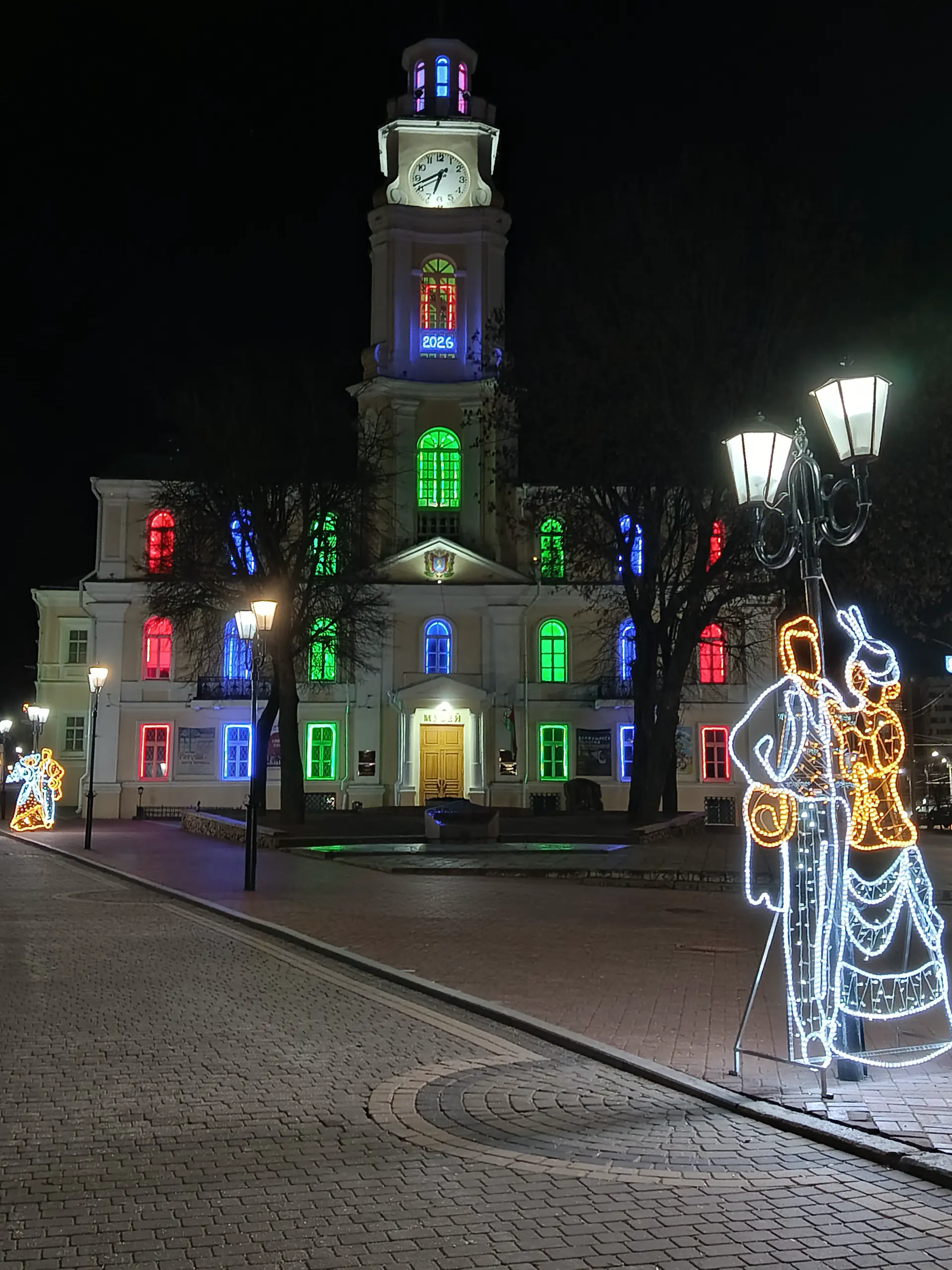 Vitebsk town hall on a winter night, light installations standing on the square.
